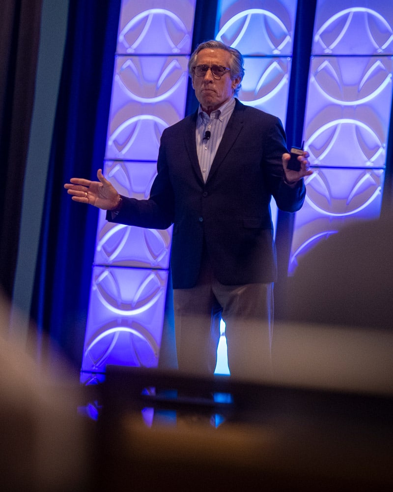 Jack Shaw on stage at speaking event with audience in the foreground